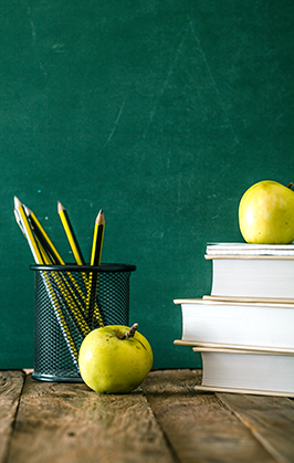 Apples, pencils, books and a blackboard