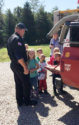 students talking to a fireman
