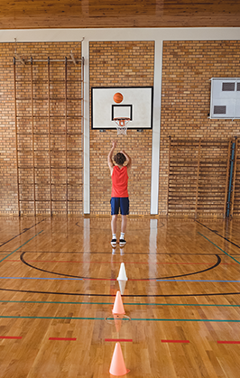 Student plays basketball in a gym