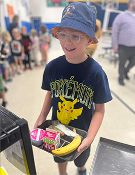 Happy student holding lunch tray in cafeteria